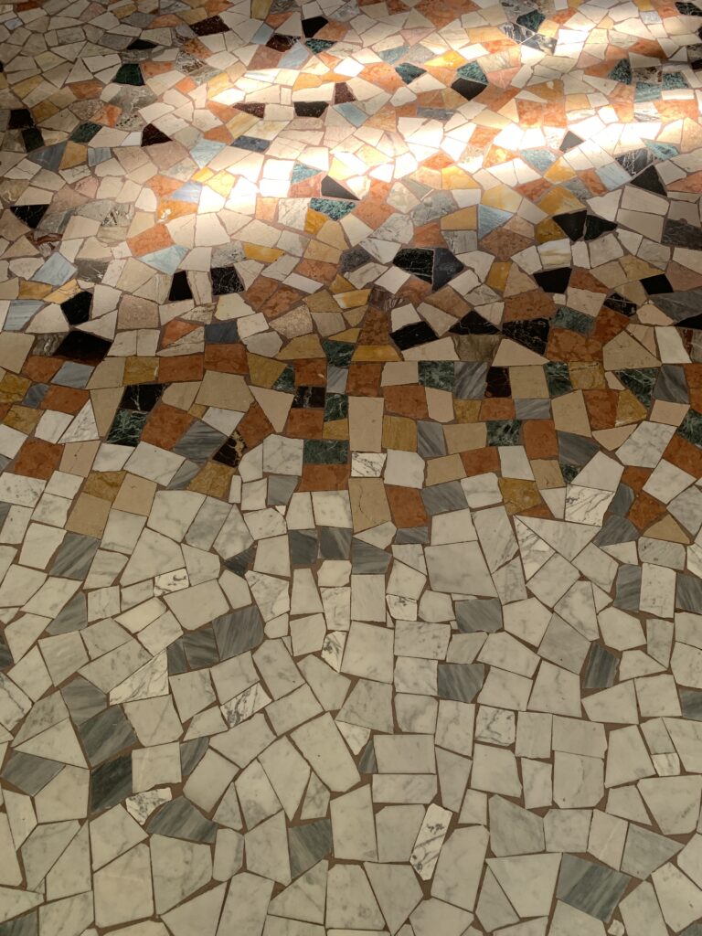 Texture pavimento storico alla palladiana (graniglia) restaurato e lucidato, con gradazione di colori dal terracotta al grigio e inserti in marmo policromo.